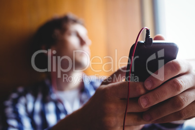 Upset student looking through window and listening music