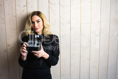 Woman holding a camera against textured background