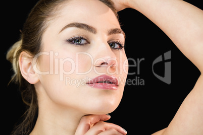 Portrait of beautiful woman posing against black background