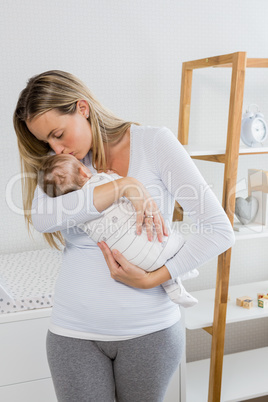 Mother holding and kissing her baby boy