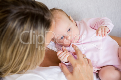 Mother playing with her baby in bedroom