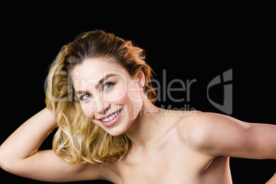 Portrait of beautiful woman smiling against black background