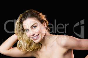 Portrait of beautiful woman smiling against black background