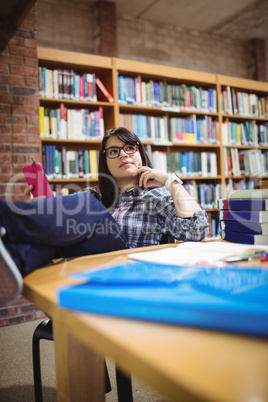 Female student sitting in library with mobile phone