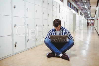 Student using laptop in locker room