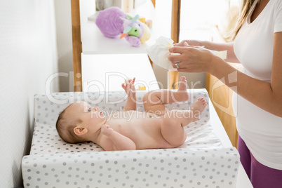 Mother changing the diaper of her baby