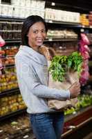 Portrait of smiling woman holding a grocery bag