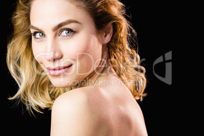 Portrait of beautiful woman smiling against black background