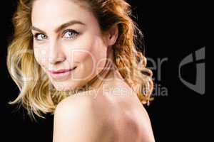 Portrait of beautiful woman smiling against black background