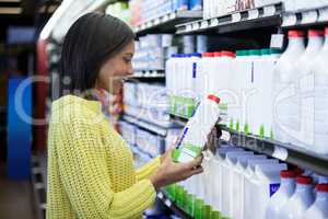 Woman looking milk bottle in dairy section