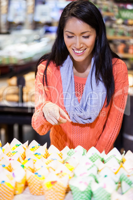 Excited woman looking at cupcakes