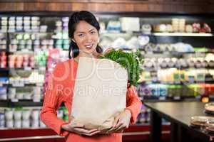 Woman holding groceries in paper bag