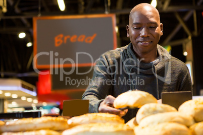 Man buying croissant bread from display counter