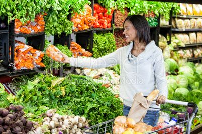 Woman buying carrot in organic section