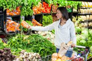 Woman buying carrot in organic section