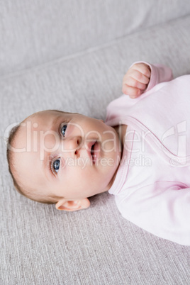 Baby lying on sofa in living room