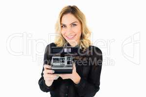 Smiling woman holding a camera against white background