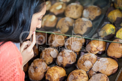 Thoughtful woman selecting sweet food