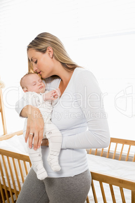 Mother holding and kissing her baby boy