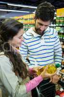 Couple buying oil bottle in grocery section