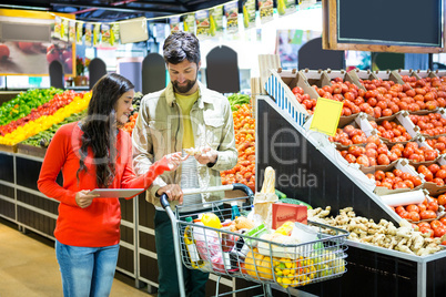 Couple using digital tablet while shopping