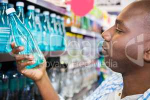 Man looking at bottle of water