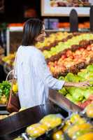 Smiling woman buying fruits in organic section
