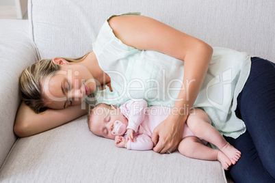 Mother sleeping with her baby in living room