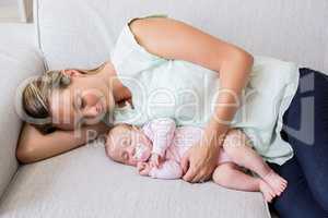 Mother sleeping with her baby in living room