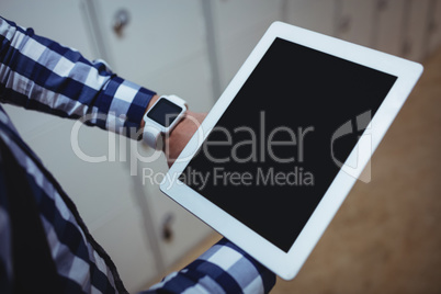 Student using digital tablet in locker room