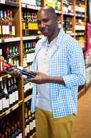 Man looking at wine bottle in grocery section at supermarket
