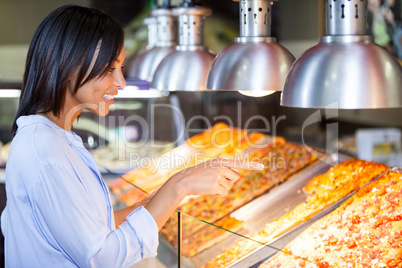 Excited woman pointing at snacks in disp