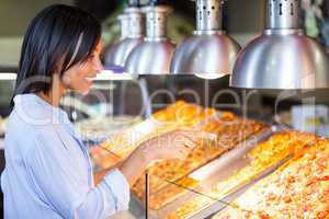Excited woman pointing at snacks in disp