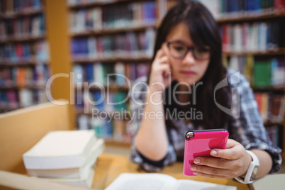 Thoughtful female student using a mobile phone