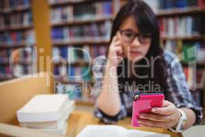 Thoughtful female student using a mobile phone