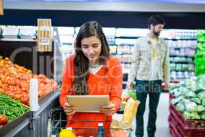 Woman using digital tablet while shopping