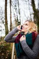 Beautiful woman talking on mobile phone in forest