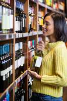 Woman selecting wine in grocery section