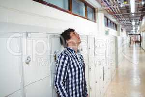 Sad student leaning on locker