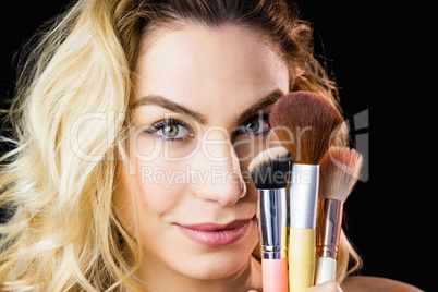 Portrait of beautiful woman posing with make-up brush