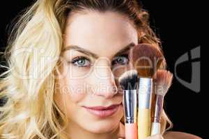 Portrait of beautiful woman posing with make-up brush