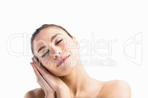 Woman posing with her eyes closed against white background
