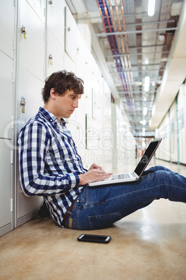 Student using laptop in locker room