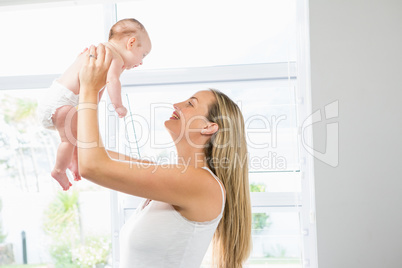 Mother playing with her baby in living room