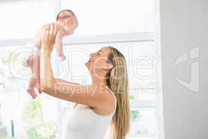 Mother playing with her baby in living room