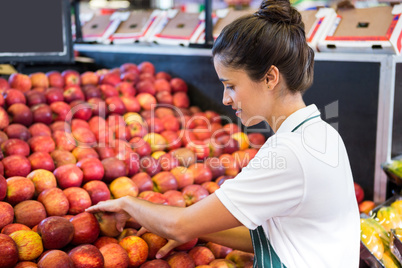 Female staff arranging fruits in organic section