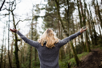 Rear view of woman standing with arms outstretched