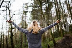 Rear view of woman standing with arms outstretched