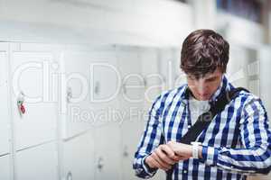 Student checking time on wrist watch in locker room
