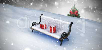Composite image of snow covered bench with gift boxes